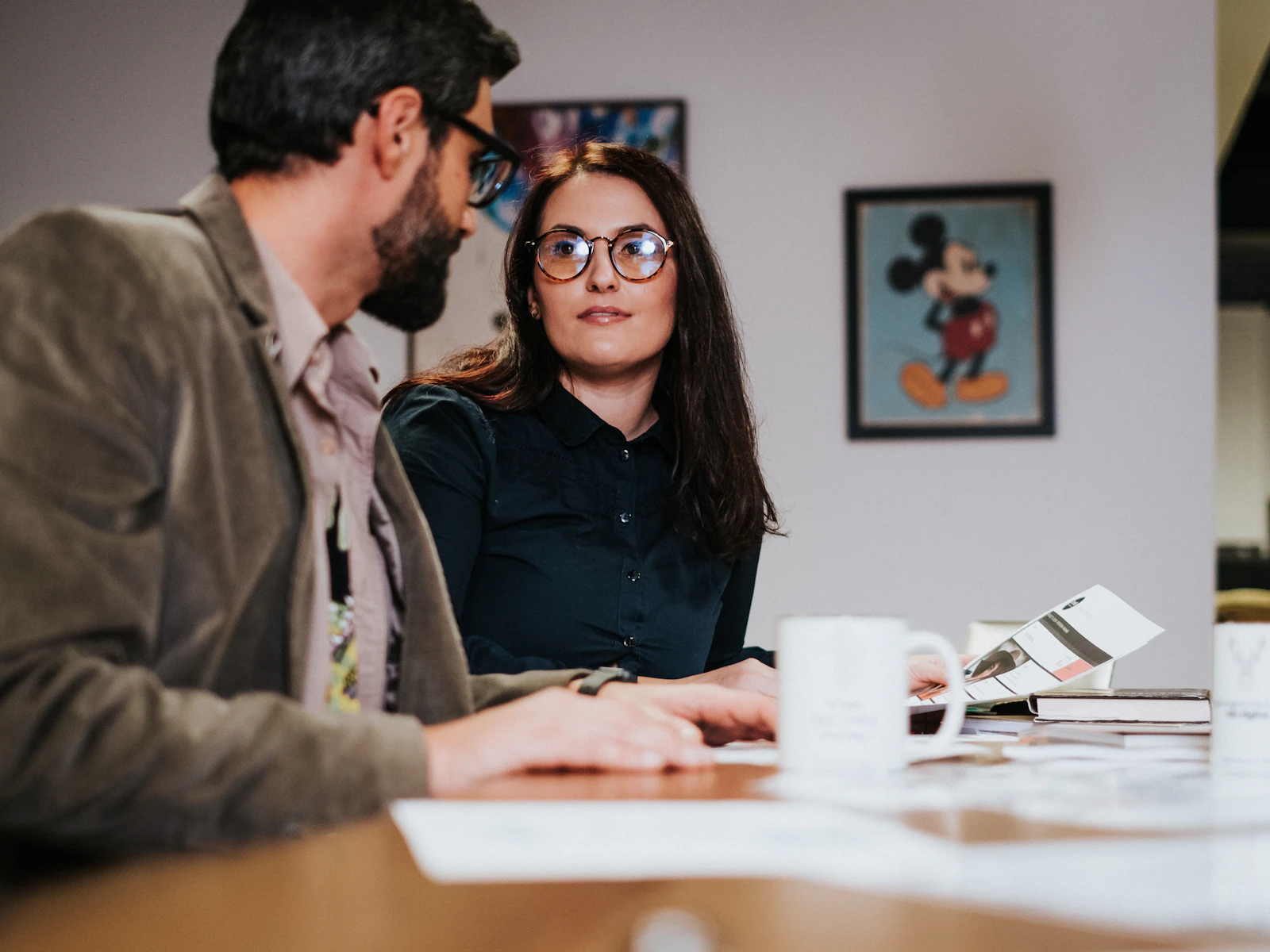 A man and a woman talking through paperwork at a table