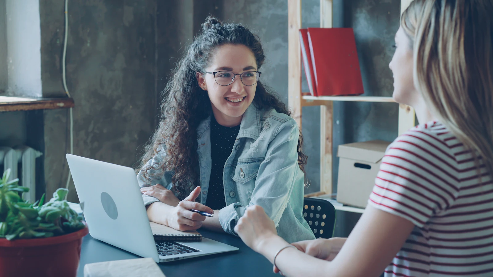 Two women in conversation over a laptop