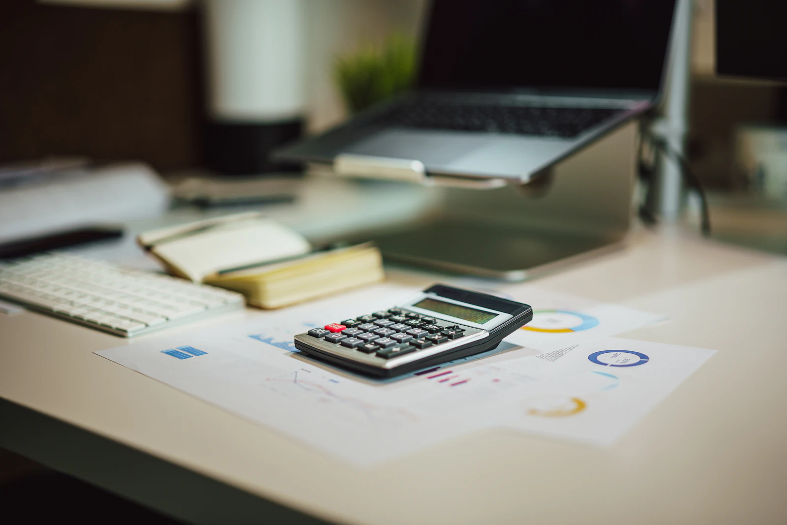 A calculator and a laptop on a desk